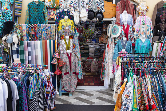 Colorful textile and souvenir shop at Siab Bazaar in Samarkand displaying traditional Uzbek robes and embroidered garments. Ideal for travel, culture, and shopping content.