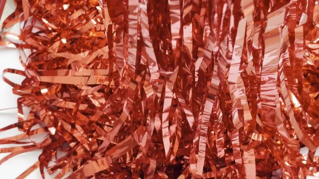 Shiny red gold tinsel slowly filling the entire screen from top to bottom, creating a festive and glamorous abstract texture isolated on a white background for any celebration