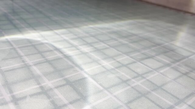 Water caustic light reflections dancing on a tiled pool bottom creating a serene and shimmering abstract pattern with a beautiful play of sunlight and moving shadows