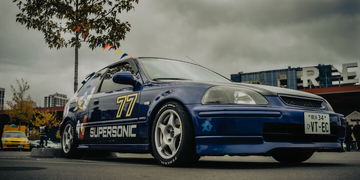 Kyiv, Ukraine - October 20, 2023. A blue modified car with custom decals and a lowered stance was displayed at Kyiv Car Fest, an automotive event featuring tuned and enthusiast vehicles.