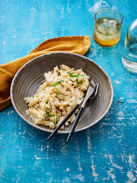 This dish features spiral pasta adorned with a creamy sauce and garnished with fresh herbs