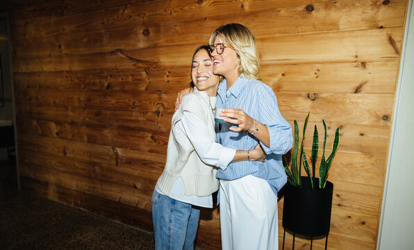 Young women hugging in casual startup office
