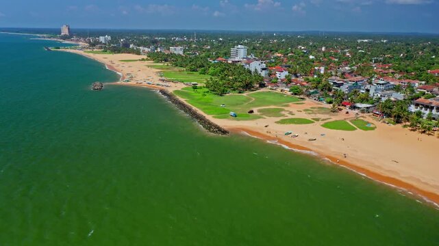 High cinematic aerial view of Negombo beach in Sri Lanka showing endless ocean, sandy coast and serene tropical seascape.
