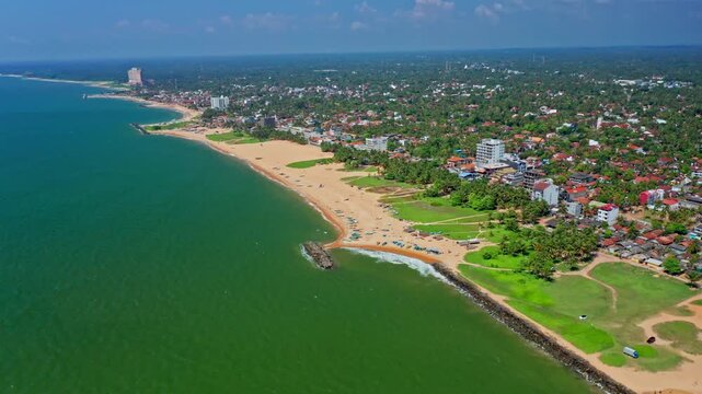 Cinematic aerial drone footage of Negombo beach and ocean showcasing turquoise waters, sandy shoreline and tropical island atmosphere.