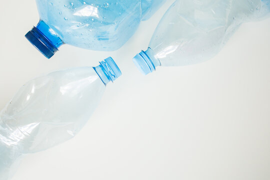Blue empty plastic bottles on white background with copy space close up. Ecological issues, plastic waste, returning bottles, recycle and reuse