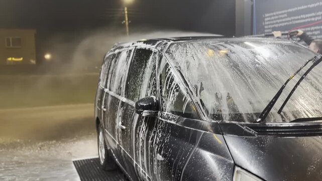 Minivan covered in soap at self-service car wash