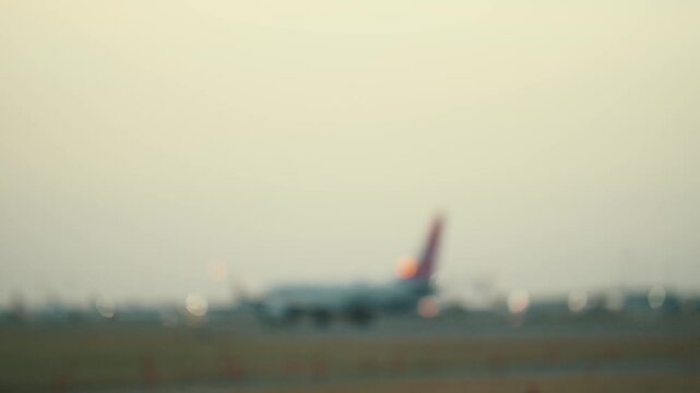 Planes taxiing on the runway during early evening at the airport in a busy travel hub