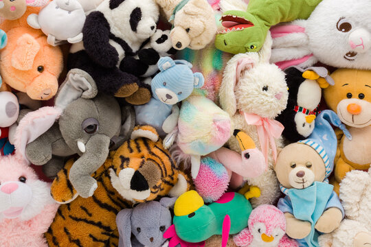 Heap of colorful soft animal toys background. Different messy baby goods. Closeup. Flat lay. Top down view.