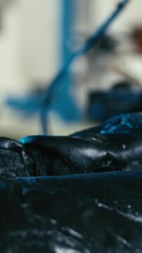 Mixing rubber mass between spinning cylinders close-up