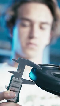 Young worker measuring product thickness