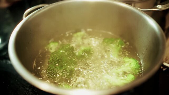 Boiling Green Broccoli Florets In Pot On Stove. Preparing Healthy Organic Meal In Kitchen