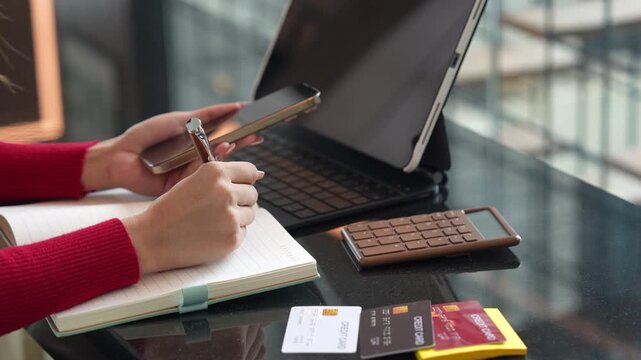Woman holding credit cards while making a successful online payment on laptop computer, representing e-commerce, digital banking, and secure online shopping at home.
