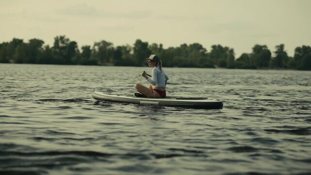 Surfer Floating On SUP Board On Lake. Summer Workout And Fitness
