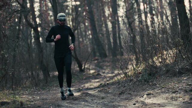 Runner Jogging Along Forest Dirt Path. Athlete Training In Autumn Woods. Cardio Workout