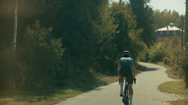 Cyclist Riding Bicycle On Rural Road And Drinking Water From Bottle. Training On Road Bike. Active Lifestyle And Cardio Workout 