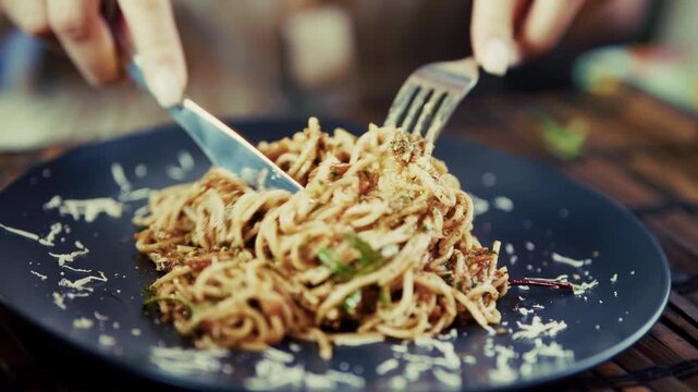 Person Eating Italian Pasta Spaghetti Bolognese With Fork And Knife. Grated Parmesan Cheese On Noodles. Hot Tasty Food