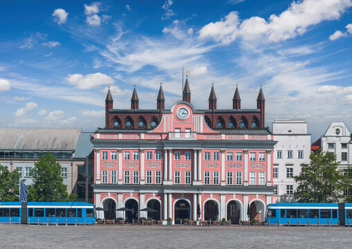 Rostock Town Hall stands on Neuer Markt with blue trams crossing the square in Rostock, Mecklenburg-Western Pomerania, Germany.