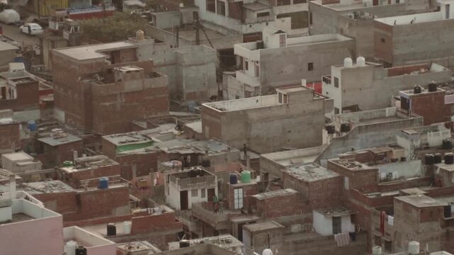 High-angle view of a densely populated urban residential area with countless rooftops and buildings characteristic of a developing country, showcasing overcrowding and urban sprawl
