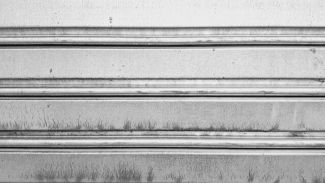 Close-up of a weathered, metallic, corrugated roller shutter or garage door.