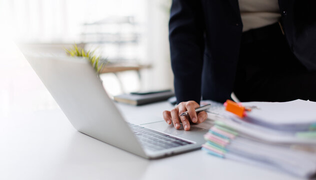 Businesswoman hands working in Stacks of paper files for searching and checking unfinished document achieves on folders papers at busy work desk office
