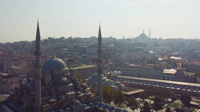 Aerial view of Istanbul Yeni Cami or New Mosque, originally named the Valide Sultan Mosque, and other historic mosque domes and tall minarets rising above dense urban skyline