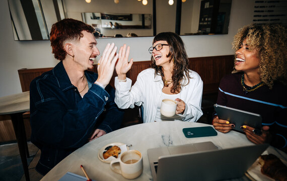 Friends sharing coffee and laughter at a cafe