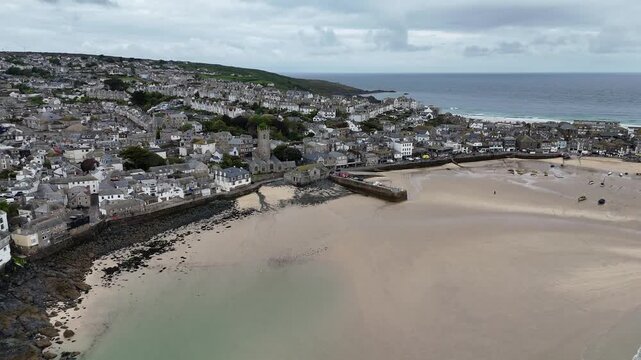 Aerial drone footage of St Ives Harbour at low tide featuring sandy beaches, fishing boats and stunning Cornish coastal scenery.