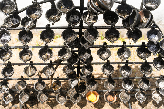 View of rows of traditional black oil lamps on a metal rack at the Japanese Peace Pagoda Rumassala in Unawatuna, Southern Province, Sri Lanka.