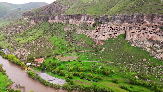 Drone aerial of Vardzia cave monastery, Georgia on a caucasian valley in Erusheti Mountain slopes above the winding Mtkvari River