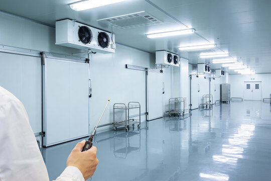 Professional inspecting a sterile cold storage facility with climate control systems