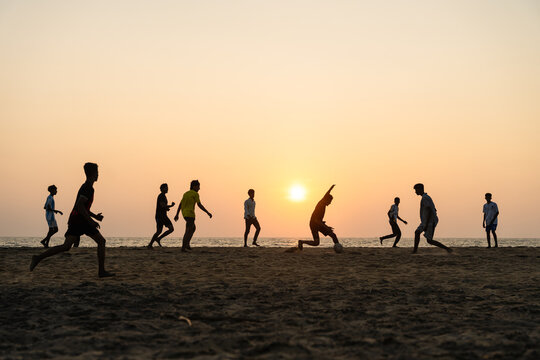 View of a group of people playing football on a sandy beach during a vibrant sunset in Galle, Southern Province, Sri Lanka.