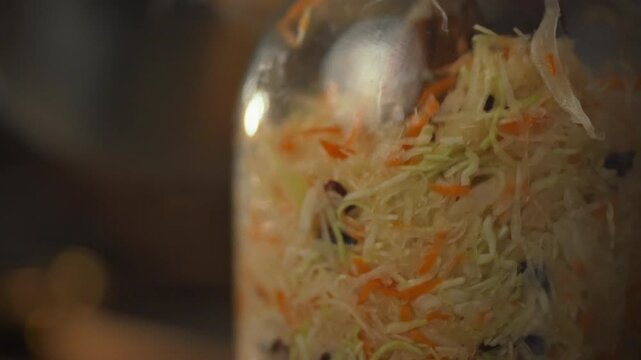 A jar is filled with freshly shredded organic cabbage, prepping for natural fermentation in a brine bath, a step in making sustainable sauerkraut for a healthy meal