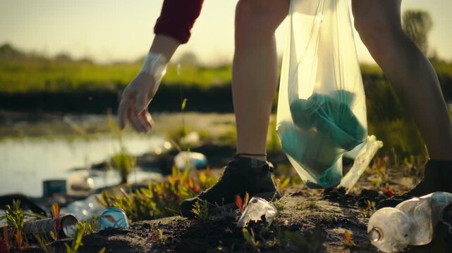 As evening falls, an eco-conscious volunteer gathers plastic waste on the riverbank, diligently sorting recyclables to promote sustainability and support conservation efforts