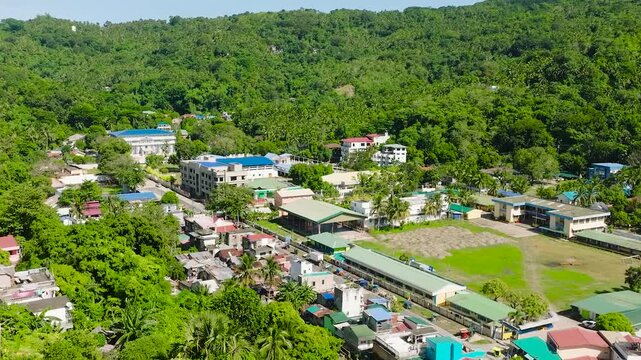 Aerial view of houses and buildings surrounded by mountain forest. Romblon City. Philippines.