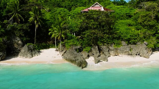 Rocks and white sand with ocean waves in Carabao Island. San Jose, Romblon. Philippines.