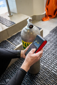 Diver using an oxygen analyzer to check a Nitrox tank before a dive