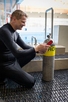 Diver using an oxygen analyzer to check a Nitrox tank before a dive