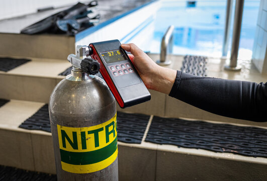 Diver using an oxygen analyzer to check a Nitrox tank before a dive