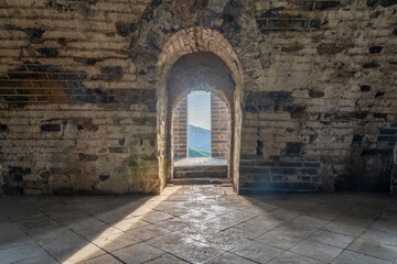 Fototapeta premium Historic Echoes Dramatic Sunbeams Piercing Through Arrow Slits Inside Jiuyan Watchtower