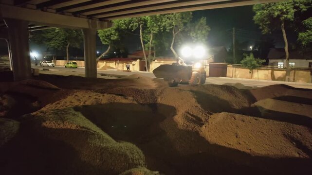 Drone on a section of a city road under repair at night