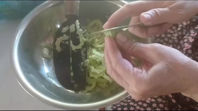 Top View of Hand Slicing Fresh Bitter Melon for Stir Fry