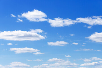 Fototapeta premium Blue sky with scattered white cumulus clouds on a clear day