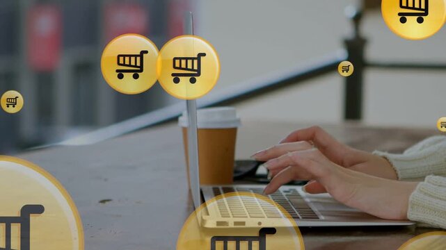 Woman typing on laptop, shopping online, making gold cart icons swelling then fading, hiding hands