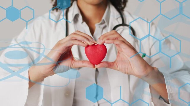 Dr holding red heart steadying as camera zooming while blue DNA hexagons accenting cardiac health