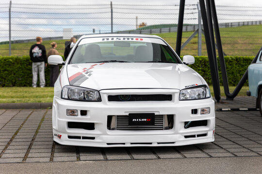 Leipzig, Germany - 9 May, 2026. Front view white Nissan GT-R R34 Nismo aggressive body kit intercooler motorsport styling parked outdoors. Iconic Japanese performance coupe tuning culture engineering