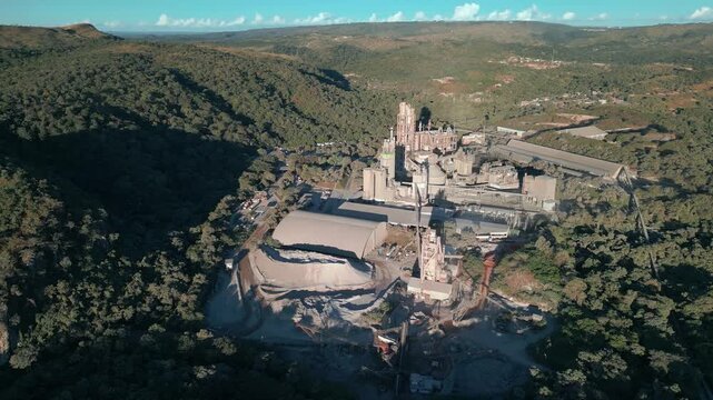 Industrial mining complex near Bras&iacute;lia, Distrito Federal, Brazil, aerial shot above quarry excavation, mineral processing plant, cement infrastructure, and surrounding Cerrado highland landscape.