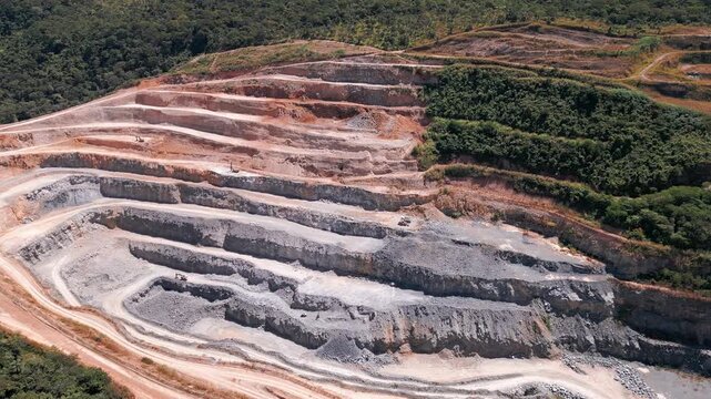Terraced quarry near Bras&iacute;lia, Distrito Federal, Brazil, revealing exposed stratified rock, erosion scars, deforestation, extraction benches, and severe Cerrado landscape transformation from mining