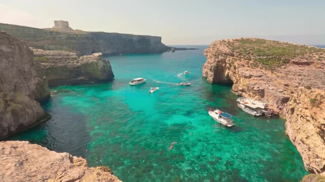 Establishing shot of small bay in Comino siland with yachts and people swimming in emerald water.