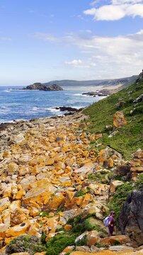 Kids clamber down short via ferrata on Robberg Circular hiking trail. Vertical