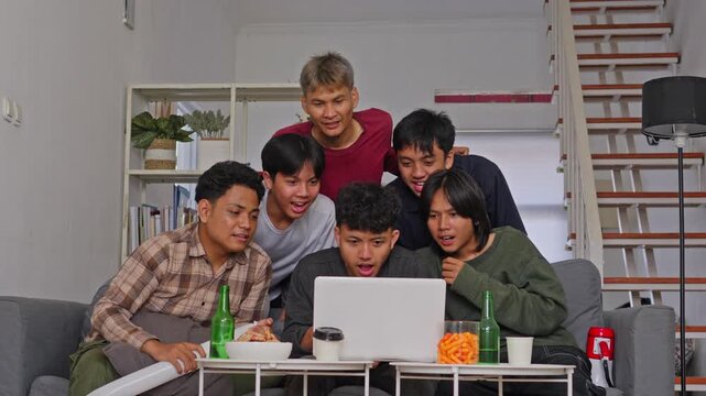 Diverse group of male friends reacting with shock and anger to yellow card while watching game